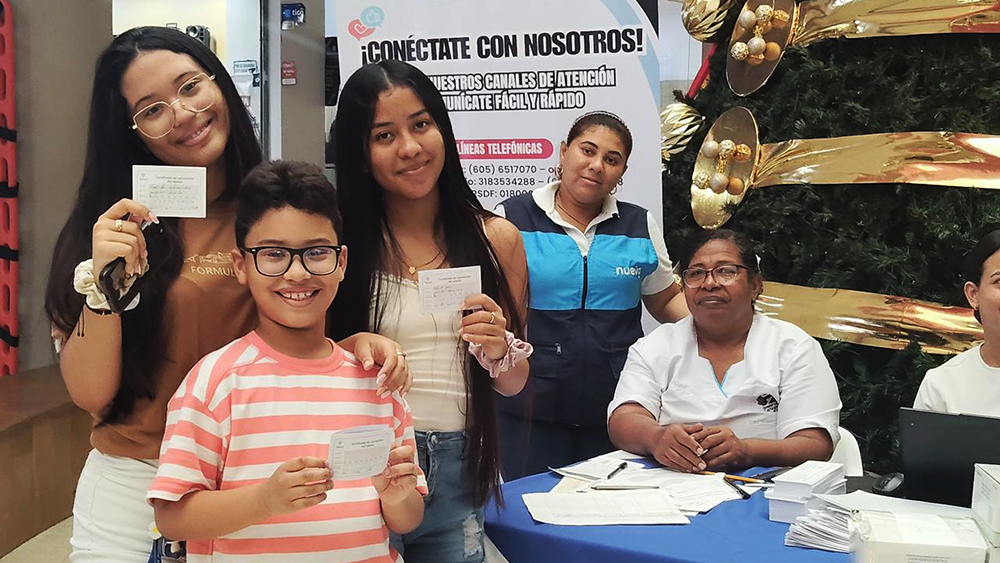 Niños posando con el carnet de vacunación