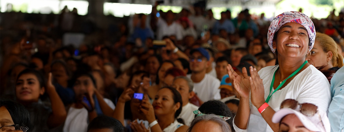 Mujer afro aplaudiendo y sonriendo