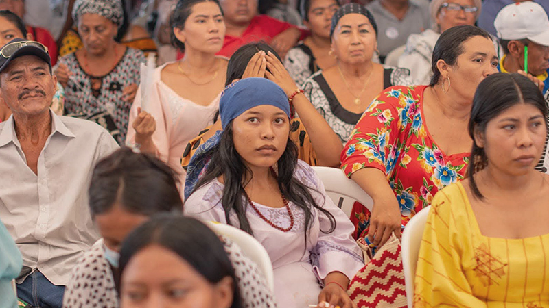 Comunidad Guajira reunida con una mujer mirando hacia la cámara
